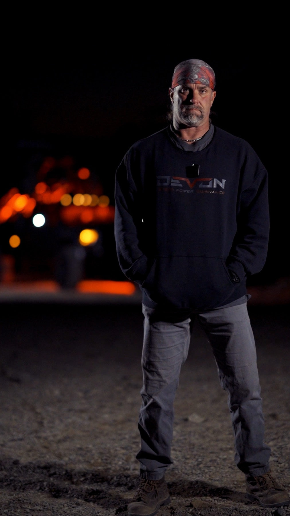 Devon Built founder at night in front of a custom truck, wearing a Devon hoodie
