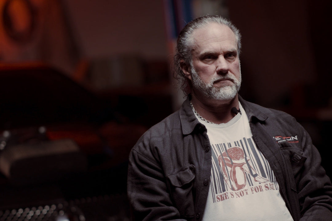 Devon Built founder in his garage wearing a faith graphic tee